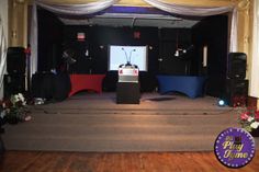 an empty stage set up for a party with flowers and decorations on the floor,