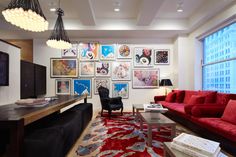 a living room with red couches and pictures on the wall