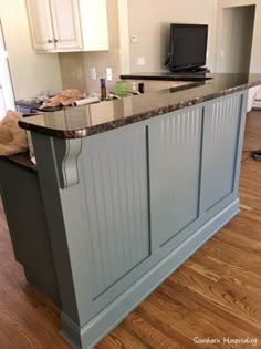 a kitchen island with granite counter tops and wooden floors