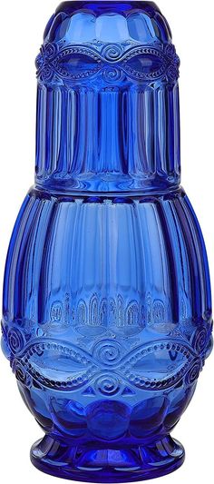 a blue glass vase sitting on top of a table