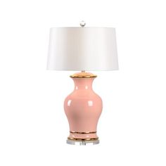 a pink table lamp with a white shade on the top and gold trim around the base