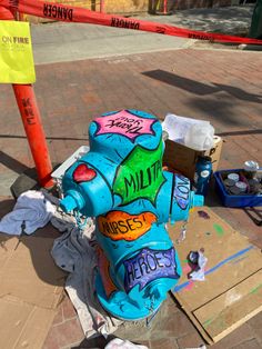 a blue fire hydrant with graffiti on it