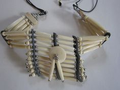 "Bone chokers are part of the Native American culture in almost every part of World. Worn as ornamentation and for protection. Wearing or carrying animal parts dates back more than 15,000 years and was believed to endow the wearer with the power of the creature. This quarter breastplate choker has 4 rows of hairpipe beads carved from Buffalo Bone. The choker measures 14\" long with 9\" of leather tie's on both sides. The middle ( breastplate) hangs 2 1/2\" down. Choker is packaged inside Organza Native Necklace, Breast Plate, Indian Choker Necklace, Bone Necklace, Bone Jewelry, Womens Chokers, Nativity Crafts, Boho Choker, Indian Necklace