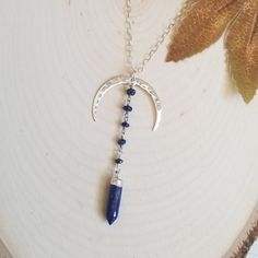 Why wear the same jewelry as everyone else? Well, now you don't have too with this unique Pendant Necklace. The moon is a symbol of change and regeneration. Lapis Lazuli, the stone of wisdom. Helps us to reconnect with our inner self. Lapis is used to form stronger bonds of friendship and generate inner peace and honesty. A hammed crescent Moon is accented with tiny Lapis Lazuli stones that are wire wrapped together and joined to a Lapis Spike stone. This unique pendant is suspended from shimmer Bohemian Sterling Silver Moon Phase Necklace, Bohemian Moon Phase Necklace In Sterling Silver, Blue Lapis Lazuli Jewelry For Festivals, Nickel Free Moon Shaped Spiritual Necklace, Spiritual Moon Shaped Nickel-free Necklace, Nickel-free Moon Shaped Spiritual Necklace, Bohemian Blue Pendant Charm Necklace, Adjustable Blue Moon-shaped Jewelry, Handmade Moon Shape Spiritual Necklace