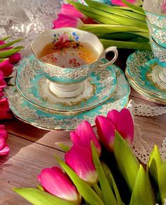 pink tulips and tea cups on a table