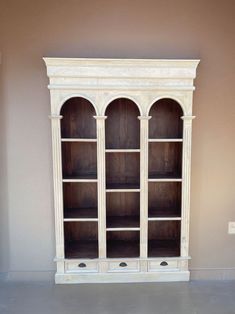 an empty white bookcase in a room