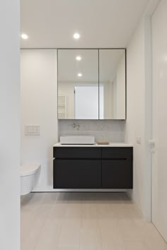 a bathroom with a sink, mirror and toilet