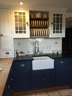 a kitchen with blue cabinets and black counter tops