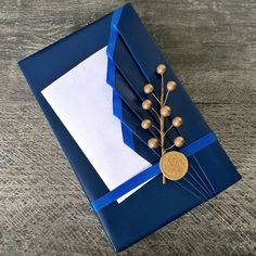 a blue folder with a flower on it and some white paper in the middle, sitting on top of a wooden table