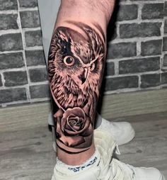 an owl with a rose tattoo on his leg is shown in black and grey ink