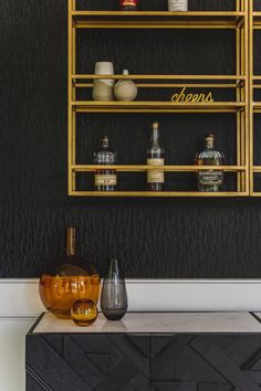 a shelf with bottles and vases on it next to a wall mounted wine rack