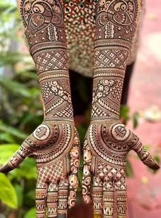 a woman's hands with henna tattoos on them