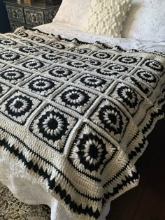 a black and white crocheted afghan on a bed