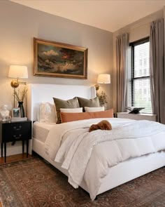 a bedroom with a large white bed and two lamps on either side of the bed