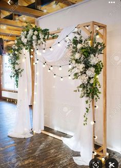 a wedding arch decorated with flowers and greenery