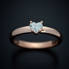 a heart shaped diamond ring on a black background