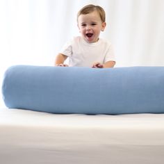 a baby sitting on top of a blue pillow