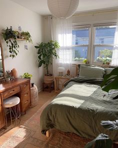 a bed room with a neatly made bed next to a dresser and mirror on the wall