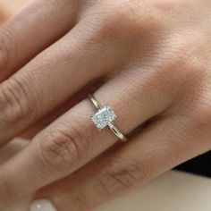 a woman's hand with a diamond ring on it