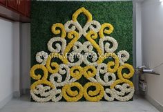 the wall is decorated with yellow and white flowers in an intricate pattern on green grass