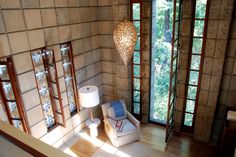 a living room filled with furniture next to two windows and a chandelier hanging from the ceiling