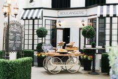 a cart that has some food on top of it in front of a building with black and white striped walls