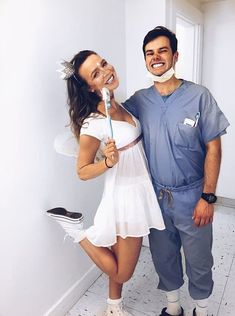 a man standing next to a woman who is holding a toothbrush in her mouth