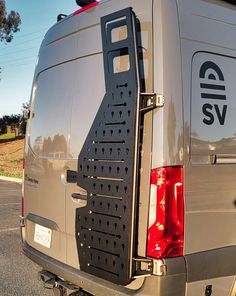 the back end of a silver van parked in a parking lot