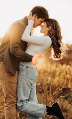 a man and woman kissing in a field