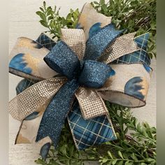 a blue and gold bow with green leaves