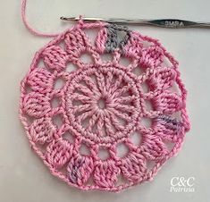 a crocheted doily with a knitting needle next to it