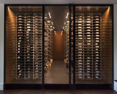 the wine cellar is full of many different types of bottles and glasses in glass doors