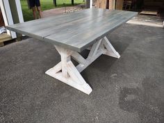 a large wooden table sitting on top of a cement floor next to a garage door