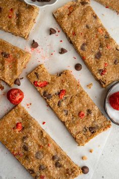 chocolate chip cookie bars cut into squares and placed on a cutting board next to a bowl of raspberries