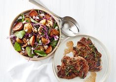 two plates with meat and vegetables on them next to a bowl of potatoes, salad