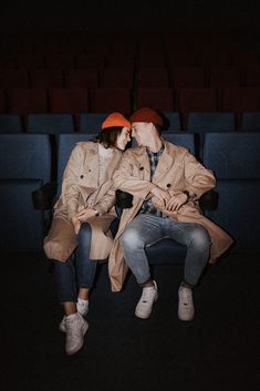 two people are sitting on a chair in the dark