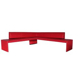 a red bench sitting on top of a white wall