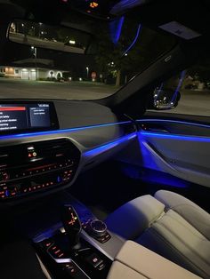 the interior of a modern car with blue lights on it's dash board and steering wheel