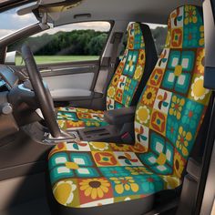 the interior of a car with colorful flowers and squares on it's seat covers