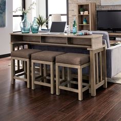 a kitchen table with stools and a laptop on it