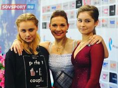 three young women posing for the camera in front of a red carpeted wall with pink flowers