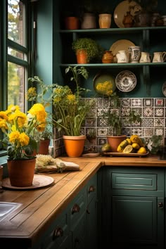 a kitchen with green cabinets and yellow flowers on the counter top, surrounded by potted plants