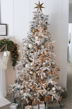 a white christmas tree with presents under it