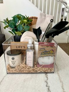 a clear box filled with items on top of a white marble counter next to a stair case