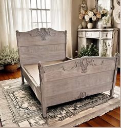 a bedroom with a bed, dresser and mirror on the floor in front of a window