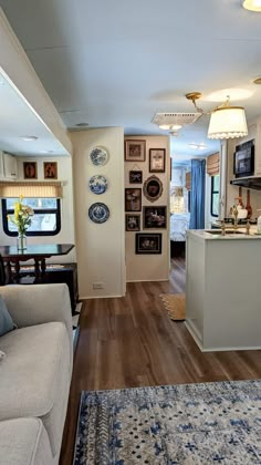 a living room filled with furniture next to a kitchen and dining room area in a home