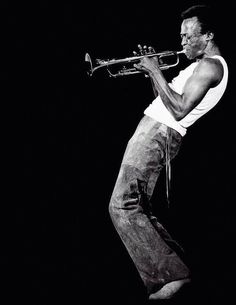 a man standing on top of a stage holding a trumpet