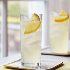 two glasses filled with lemonade on top of a table