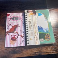 two notebooks sitting on top of a wooden table