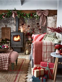 a living room filled with furniture and a fire place next to a wall covered in christmas decorations